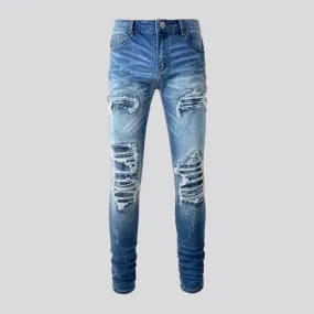 Damaged men's whiskered jeans